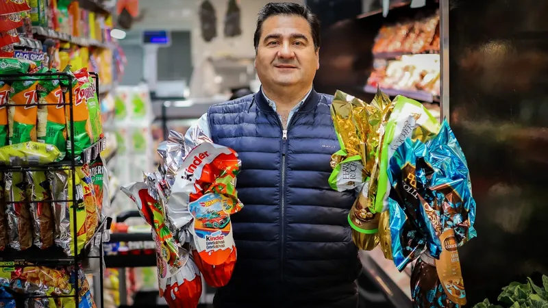 Nuno sostiene huevos de Pascua de chocolate en envolturas de colores en un pasillo de Victor’s